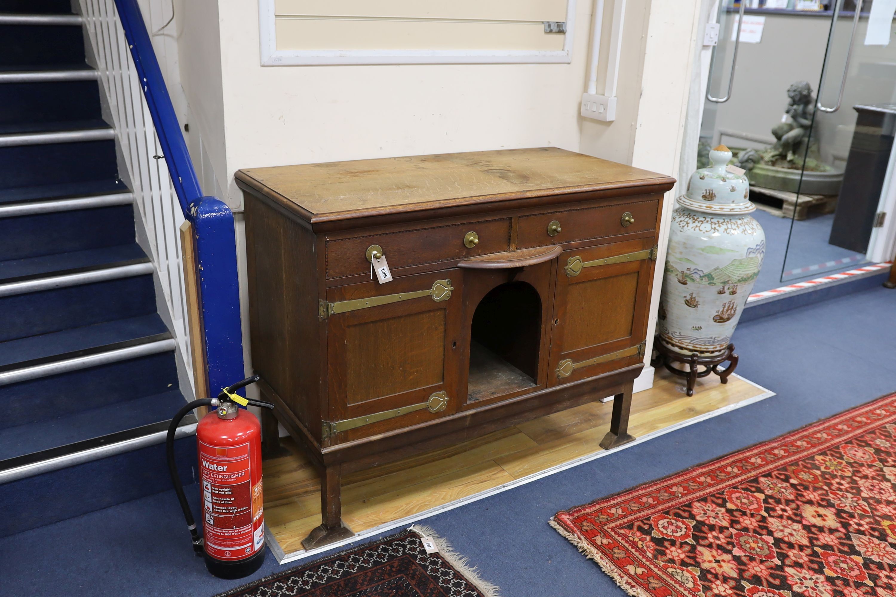 An Art Nouveau brass mounted oak buffet in the style of Voysey, length 124cm, depth 60cm, height 99cm